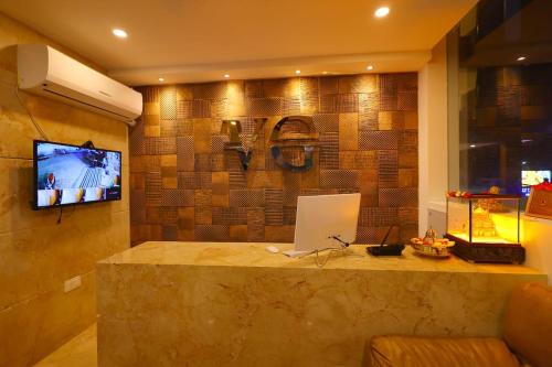 a room with a counter with a laptop and a tv at Hotel Vijaya Grand in Srikalahasti