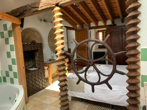 1 dormitorio con 1 cama en una habitación con chimenea en Habitaciones Rurales La Vertedera I, en Villar de Ciervo