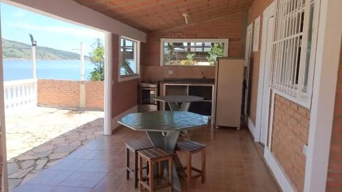 eine Küche mit einem Tisch und Meerblick in der Unterkunft Rancho Espelho D'água in Capitólio
