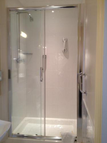 a shower with a glass door in a bathroom at Crown & Mitre Hotel in Carlisle