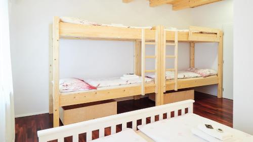 two bunk beds in a room with wood floors at Apartmány Habánská, celý dům in Pouzdřany