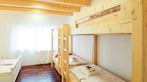 two bunk beds in a room with a window at Apartmány Habánská, celý dům in Pouzdřany