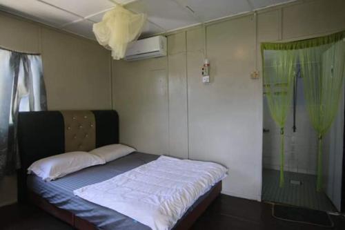 a small bedroom with a bed and a shower at Long Beach Garden in Kampung Kuala Besut