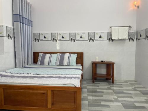 Schlafzimmer mit einem Bett und einem Beistelltisch in der Unterkunft Thien Ngoc Hostel in Cần Thơ