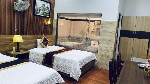 a hotel room with two beds and a bath tub at Phi Hùng Hotel in Tam Ky