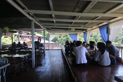 a group of people sitting at tables in a restaurant at Long Beach Garden in Kampung Kuala Besut