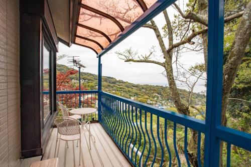 a balcony with a table and chairs and a tree at ゴンドラヴィラ イン熱海2階HakoneAtamiYugawara in Atami