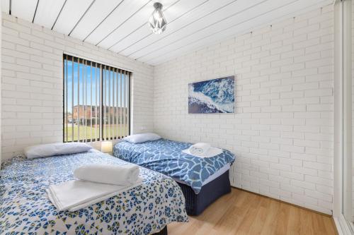 2 camas individuales en una habitación con ventana en Apollo Unit 25 Ground Floor, en Narooma