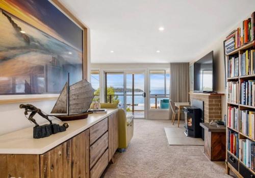 a living room with a book shelf with a boat on it at 'The Alonnah' Beach House - Main House & Unit in Alonnah
