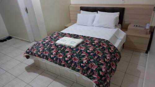 um quarto com uma cama com duas toalhas em Hotel Dalias em Guarulhos