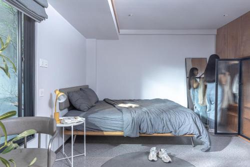 a bedroom with a bed and a table with shoes at M Village Living Võ Thị Sáu in Ho Chi Minh City