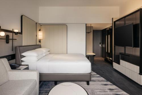 a hotel room with a bed and a tv at Hilton Singapore Orchard in Singapore