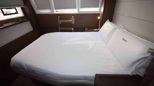 a large white bed in a small room with a window at Aquamarine in Galveston