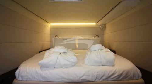 Una cama blanca con dos almohadas encima. en Aquamarine, en Galveston