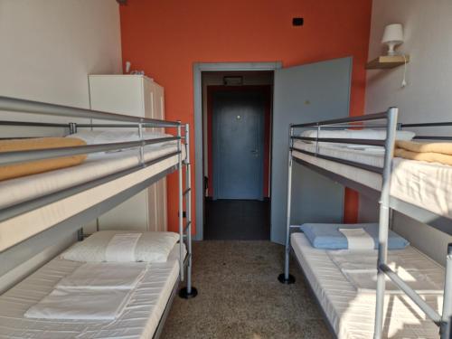 a room with three bunk beds and a hallway at B&B e Ostello, Parco di Monza, CASCINA COSTA ALTA in Monza