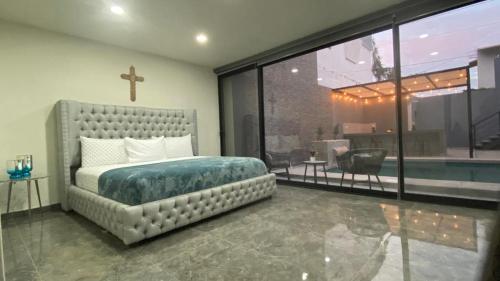 a bedroom with a bed and a large window at Suites Marvento in Ensenada