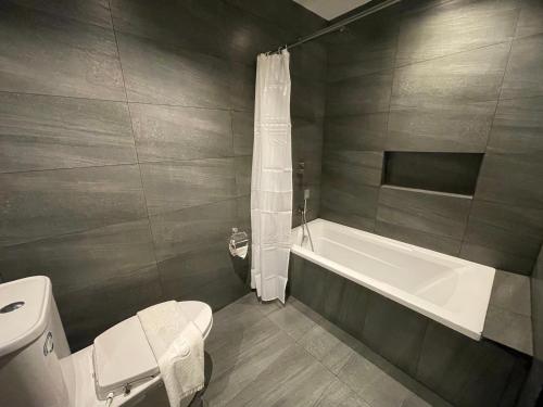 y baño con aseo y bañera. en Luisita Central Park Hotel en Tarlac