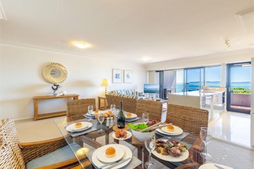 a dining room with a table with food on it at Florentine 14 - 11 Columbia Close Aircon Wifi unsurpassed water views in Nelson Bay