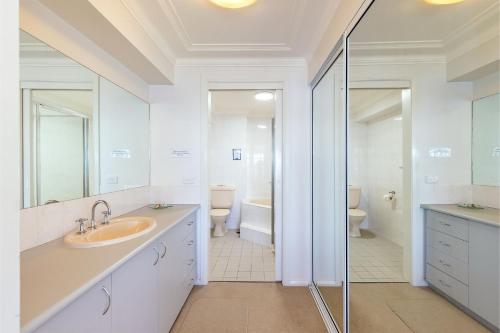 a white bathroom with a sink and a shower at Florentine 14 - 11 Columbia Close Aircon Wifi unsurpassed water views in Nelson Bay