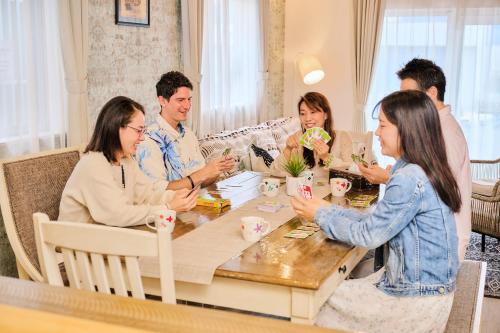 a group of people sitting around a table at ペンション マカナレアリゾート沖縄 in Ginowan