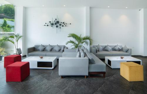 a living room with couches and tables and a chandelier at The Terrace by Ladder Mgd by Citrine in Trivandrum