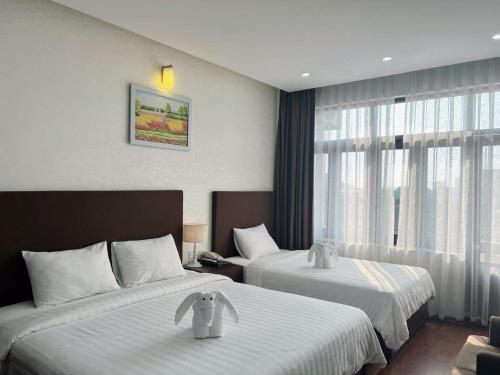 Bình Minh Hotel tesisinde bir odada yatak veya yataklar