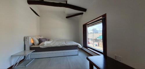 een slaapkamer met een bed en een groot raam bij Yachtie Inn Mokpo in Mokpo