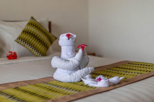 a white towel doll sitting on top of a bed at Sarivanna Penida in Nusa Penida