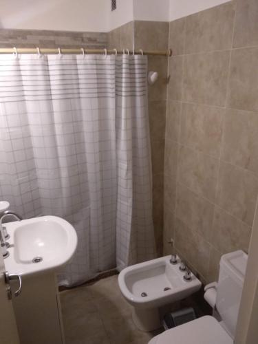 Baño blanco con lavabo y aseo en Departamento Temporario Villa María en Villa María
