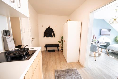 a kitchen with a white refrigerator and a living room at Deluxe Suite - Parking - Workspace in Gießen