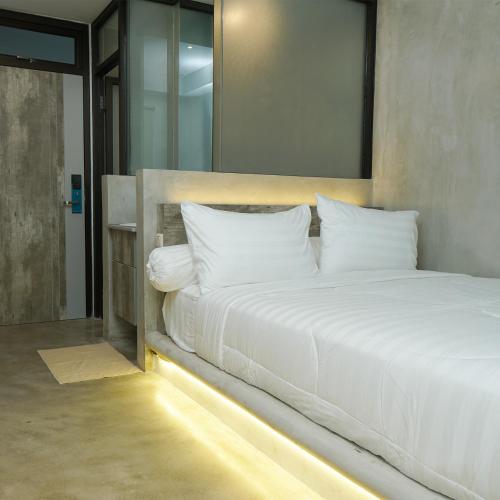 a bedroom with a large white bed with a mirror at DParagon Jakarta Timur in Jakarta