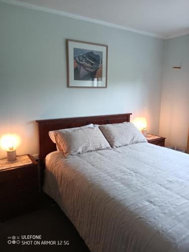 a bedroom with a large bed with two night stands at Flying Plate Saloon in Waimate