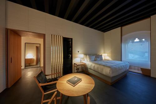 a hotel room with a bed and a table and a table sidx sidx at Casa Palacio PAREDES SAAVEDRA by ATRIO in Cáceres