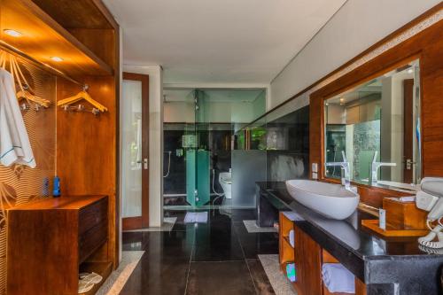 a large bathroom with a sink and a mirror at The Leaf Jimbaran in Jimbaran