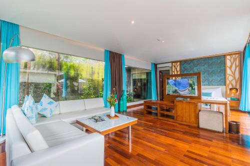 a living room with a white couch and a table at The Leaf Jimbaran in Jimbaran