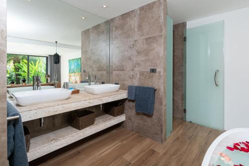 La salle de bains est pourvue de 2 lavabos et d'un grand miroir. dans l'établissement Cozy Pool Villa Naiyang Beach, à Ban Sakhu