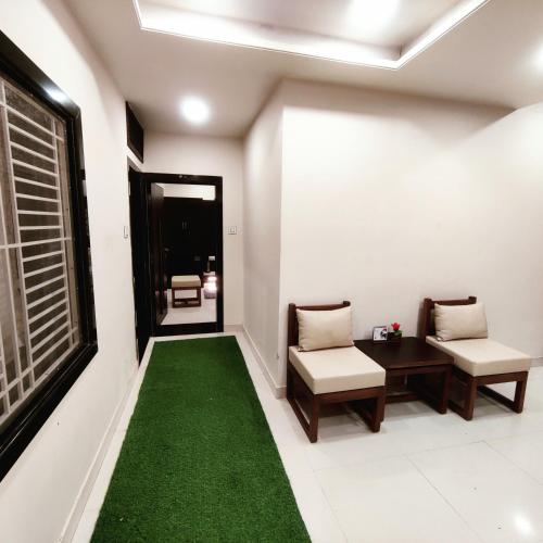 a hallway with two chairs and a green carpet at Abu Inn, Mount Abu - The Luxury Boutique Stay in Mount Ābu