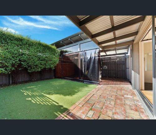 a patio with a green lawn in front of a house at Entire contemporary home in Ascot Vale in Melbourne