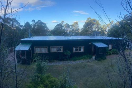 a house with a tin roof on top of it at Gumleaves Bush Retreat in Woodbridge