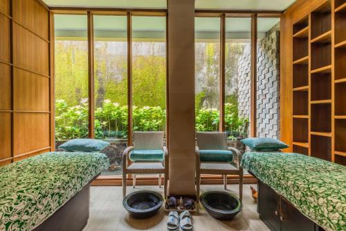 a room with two beds and a large window at The Leaf Jimbaran in Jimbaran