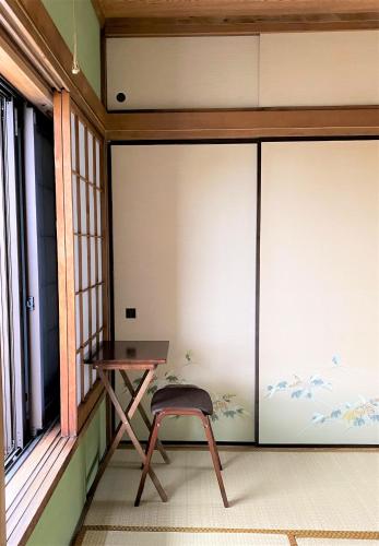 a table and a stool in front of a window at 江ノ島に近い富士山も眺める湘南の丘のヴィラーーー日本スタイルを体験できるTatami Room in Fujisawa