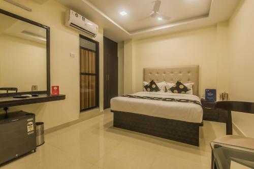 a bedroom with a large bed in a room at Super Hotel O Palace Inn Near Don Bosco (Borivali) Metro Station in Mumbai