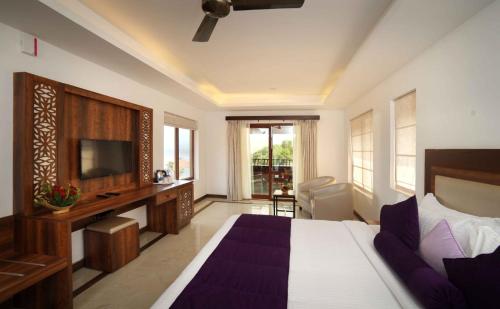 a bedroom with a bed and a television in a room at CONTOUR ISLAND RESORT & SPA by CITRINE in Tariyod