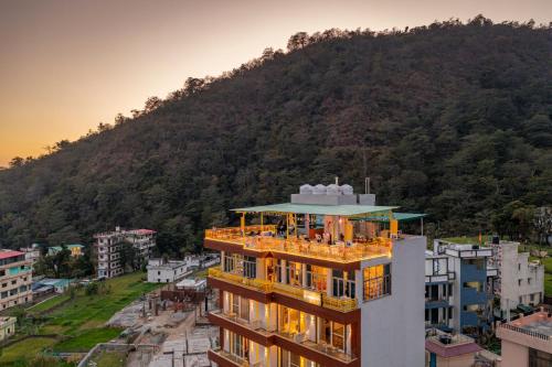 ein Gebäude mit einem Berg im Hintergrund in der Unterkunft The Hosteller Rishikesh, Upper Tapovan in Rishikesh