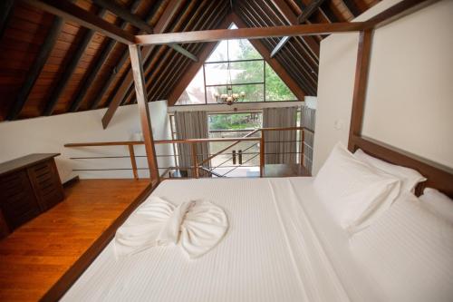 a bedroom with a large white bed in a attic at Celestia Wellness Resort in Bentota