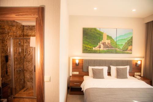 pokój hotelowy z łóżkiem i prysznicem w obiekcie Deryaman Hotel Trabzon w mieście Trabzon
