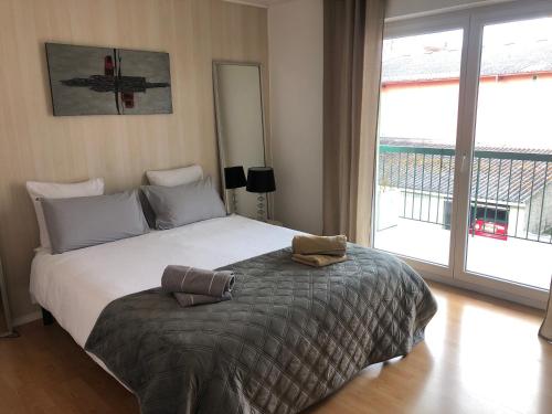 sypialnia z dużym łóżkiem i dużym oknem w obiekcie Appartement l'œil de Colmar w mieście Colmar