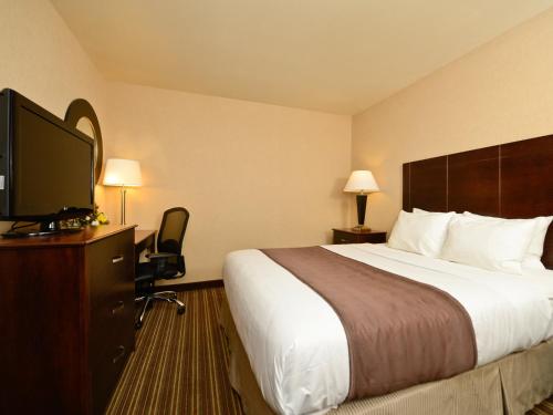 a hotel room with a bed and a flat screen tv at Yellowstone West Gate Hotel in West Yellowstone