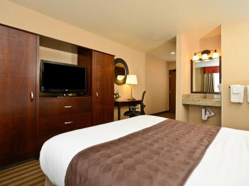 a hotel room with a bed and a flat screen tv at Yellowstone West Gate Hotel in West Yellowstone