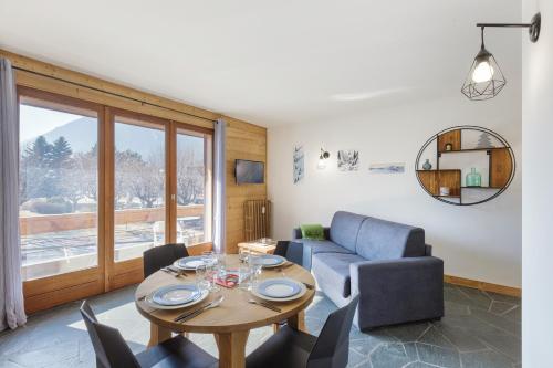 a living room with a table and a couch at Appartement Flégère et Golf - Happy Rentals in Chamonix-Mont-Blanc